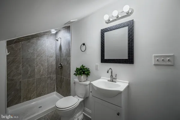 a bathroom with a toilet a sink and mirror