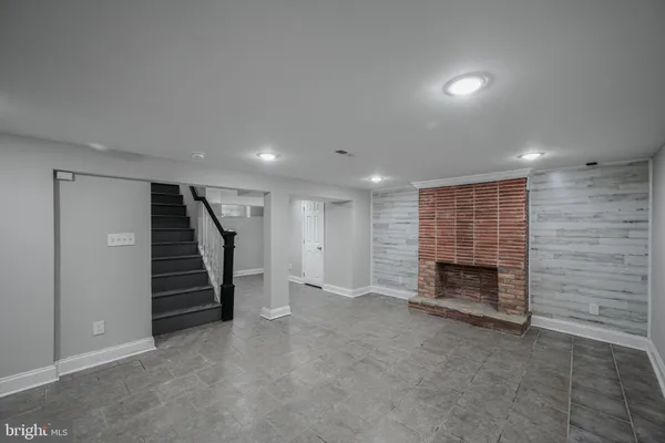 an empty room with a fireplace and stairs