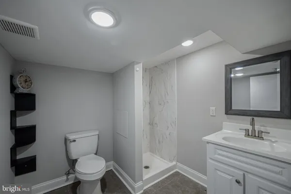 a bathroom with a granite countertop sink a toilet and a mirror