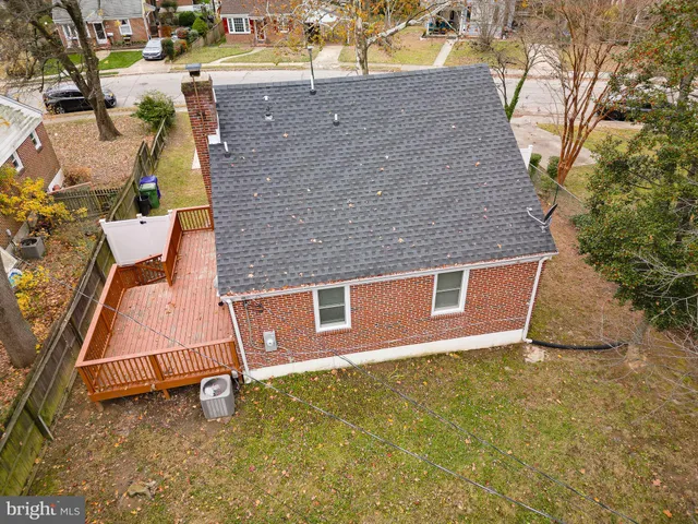 an aerial view of a house with a yard and large tree