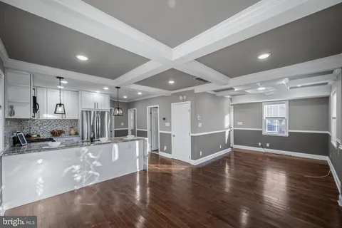 a view of a large kitchen with a sink and wooden floors