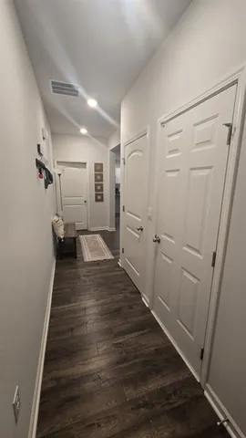 a view of a hallway with wooden floor