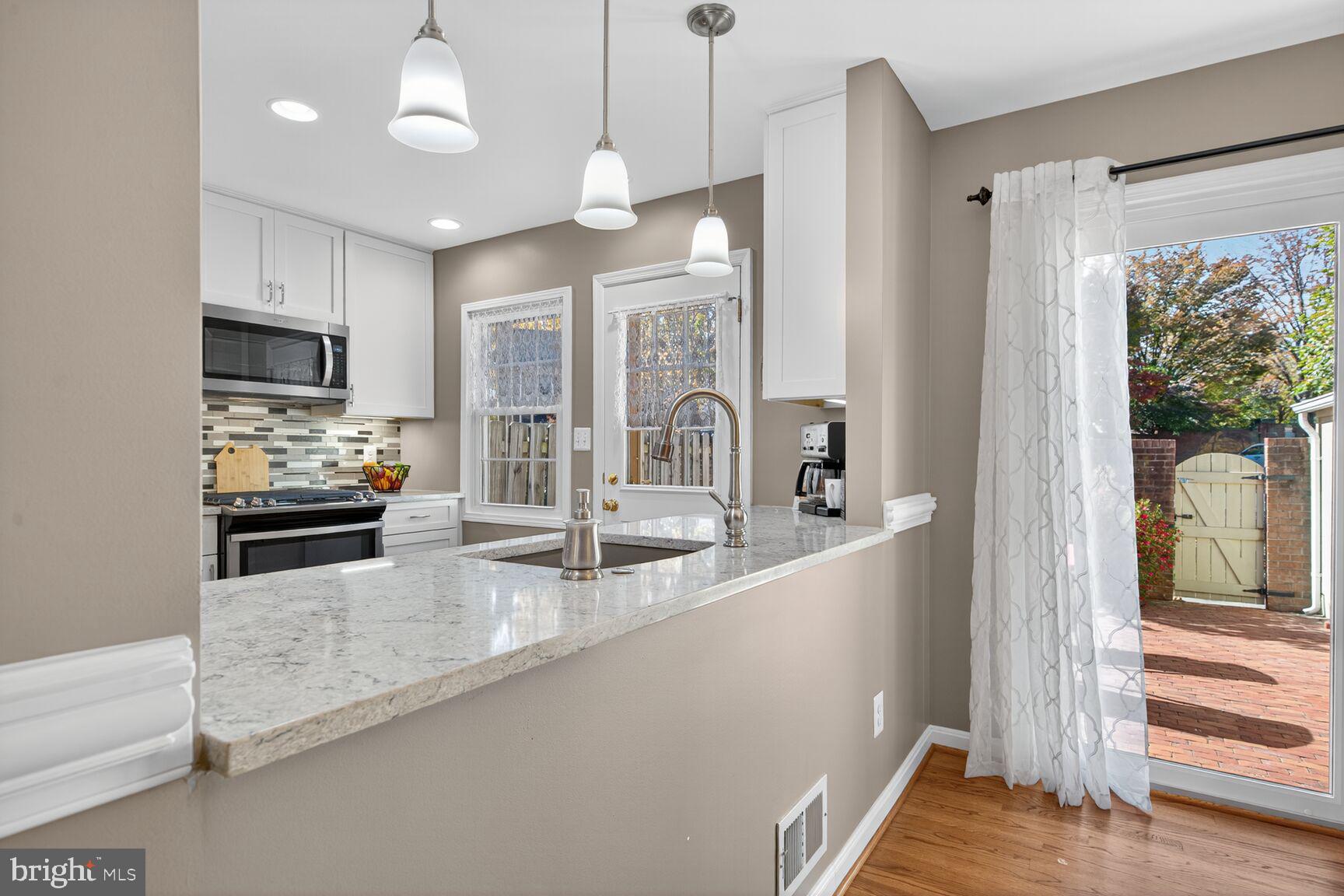 5944 Queenston Street Springfield, VA 22152 - Photo 17 of 60 a large kitchen with granite countertop a large window and a sink