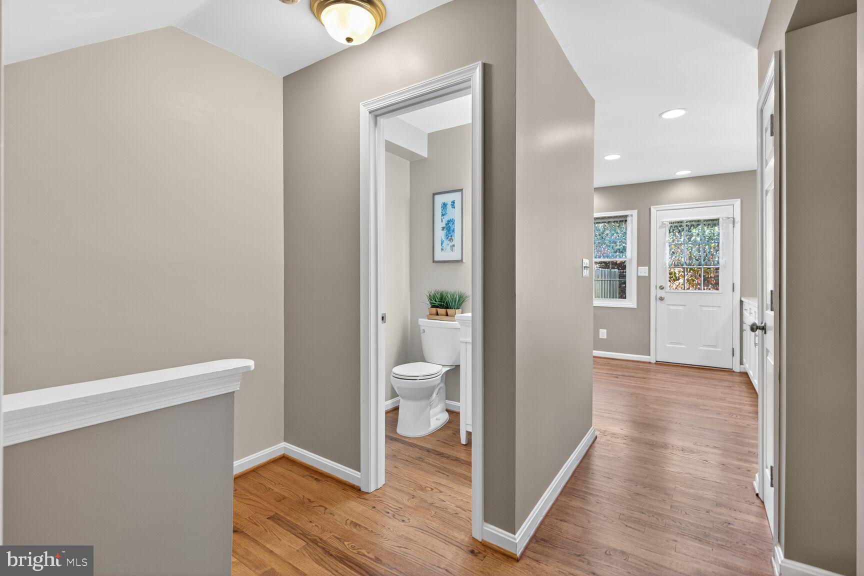 5944 Queenston Street Springfield, VA 22152 - Photo 27 of 60 a view of a hallway with wooden floor and a living room