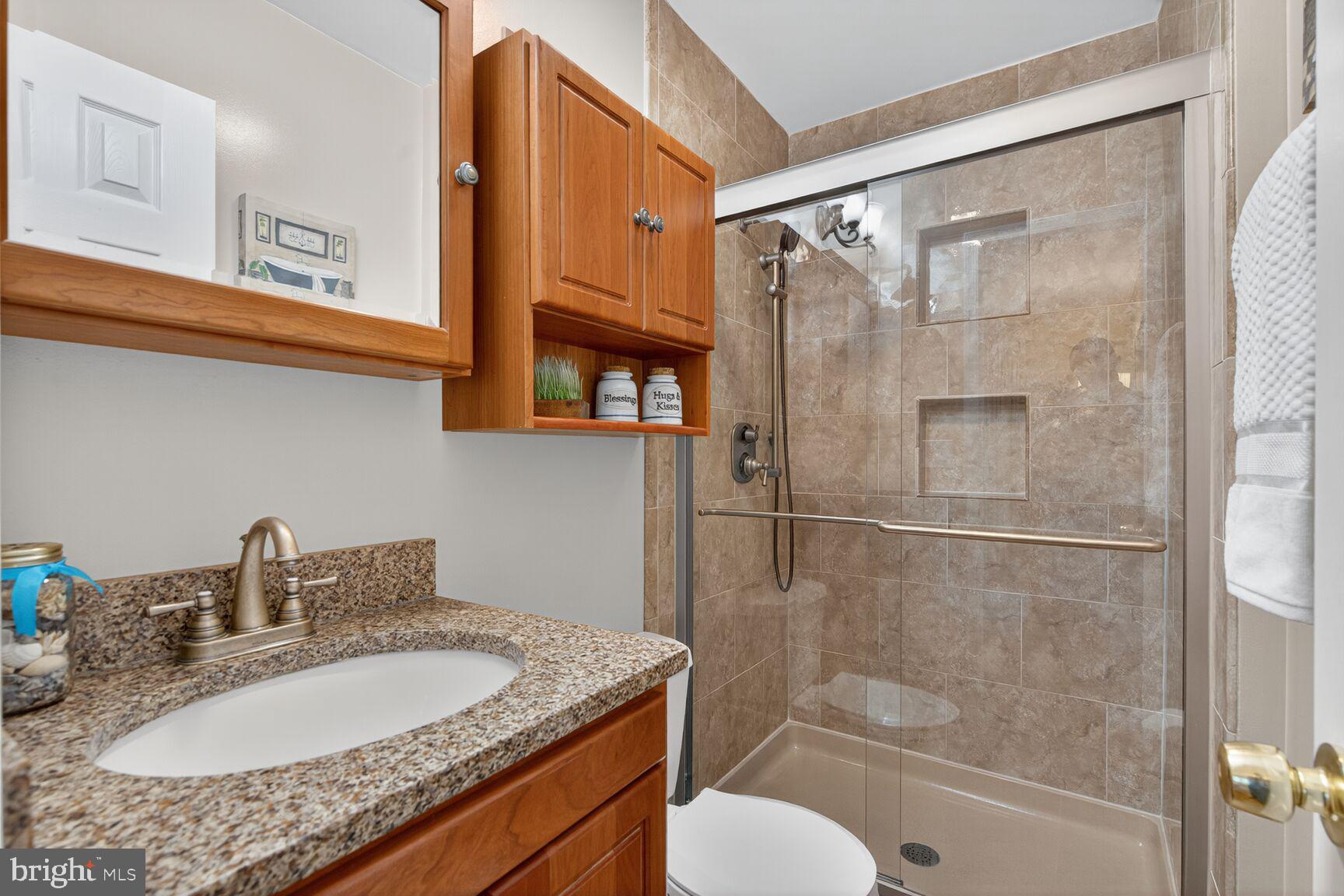 5944 Queenston Street Springfield, VA 22152 - Photo 33 of 60 a bathroom with a granite countertop sink toilet and shower