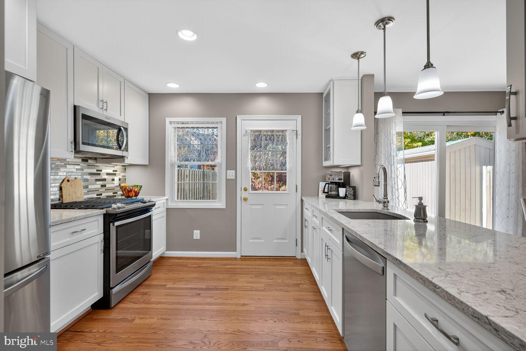 5944 Queenston Street Springfield, VA 22152 - Photo 5 of 60 a large kitchen with stainless steel appliances granite countertop a lot of counter space and wooden floor
