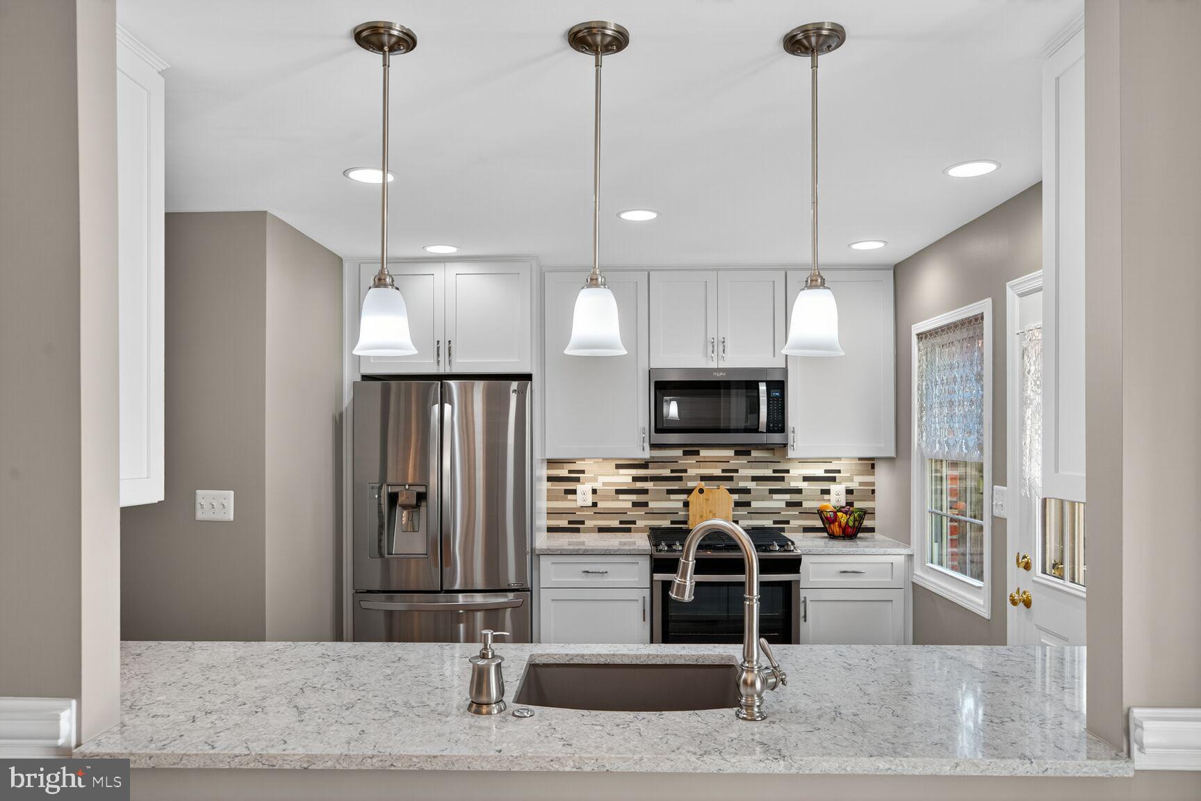 5944 Queenston Street Springfield, VA 22152 - Photo 9 of 60 a kitchen with stainless steel appliances kitchen island granite countertop a refrigerator a stove and a sink