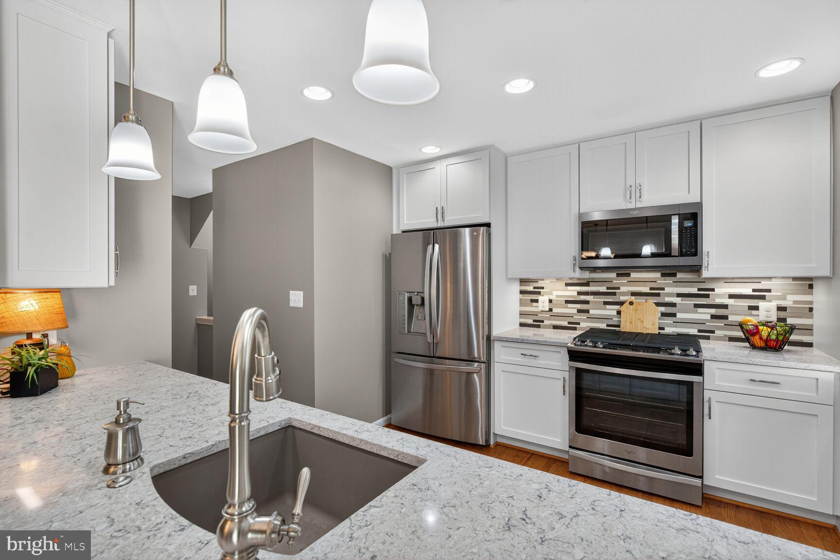 5944 Queenston Street Springfield, VA 22152 - Photo 10 of 60 a kitchen with stainless steel appliances granite countertop a refrigerator and a sink