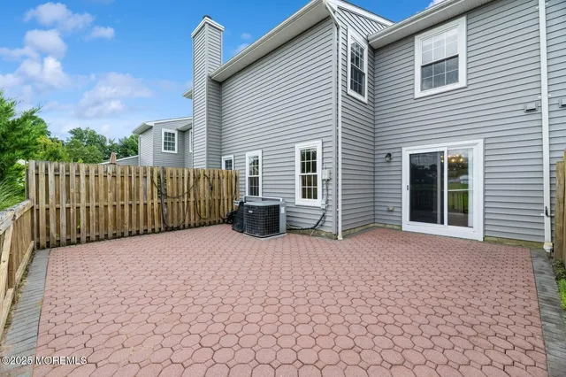 a view of a house with a small yard and wooden fence