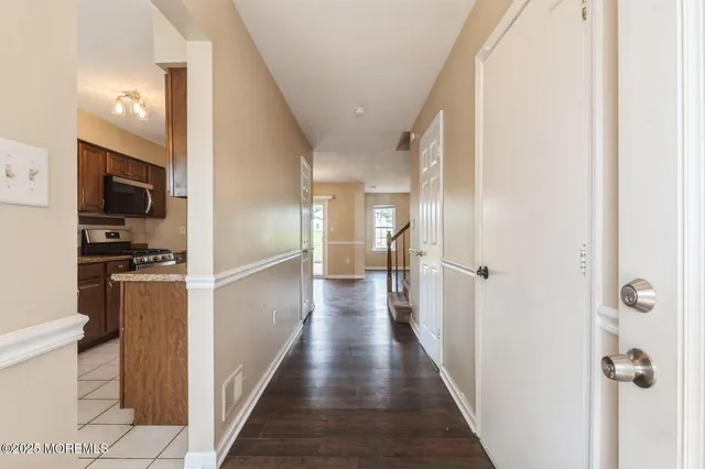 a view of a hallway with wooden floor and windows