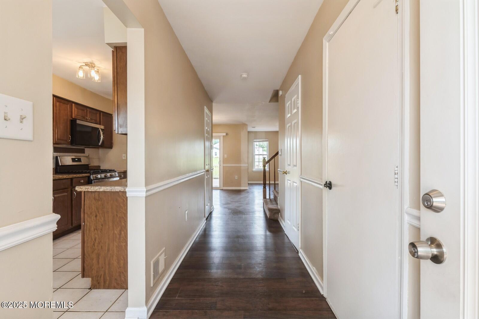 7 Sloop Square Freehold, NJ 07728 - Photo 4 of 30 a view of a hallway with wooden floor and windows