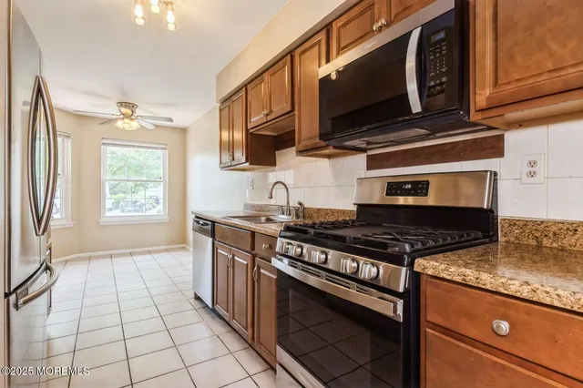 a kitchen with stainless steel appliances granite countertop a stove and a microwave