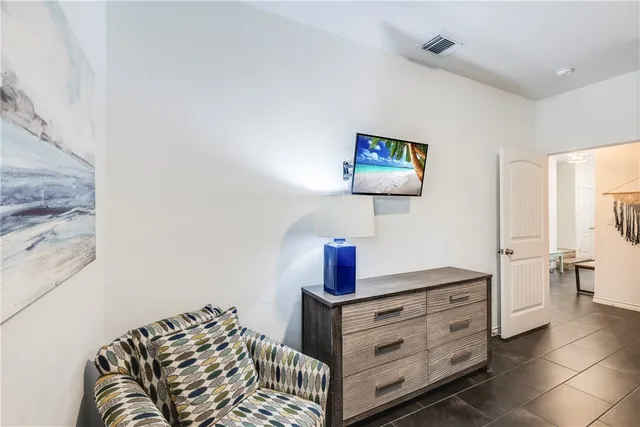 a bedroom with a bed and a lamp on the dresser