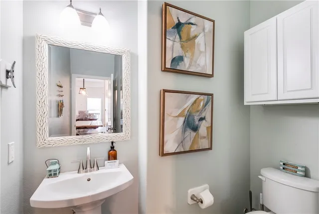 a bathroom with a toilet a sink and mirror