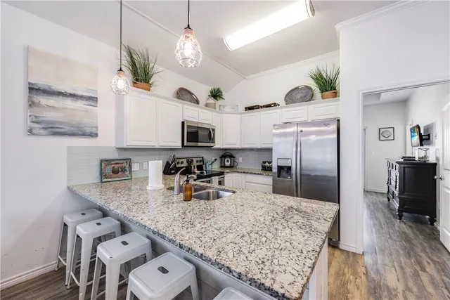 a kitchen with stainless steel appliances granite countertop a sink refrigerator and microwave