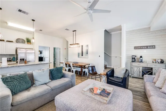 a living room with furniture kitchen view and a rug