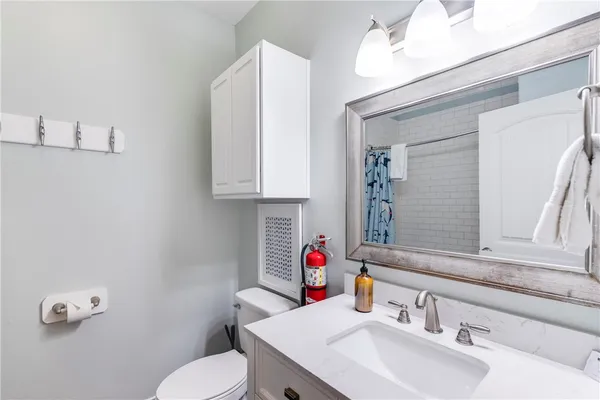 a bathroom with a sink vanity mirror and toilet