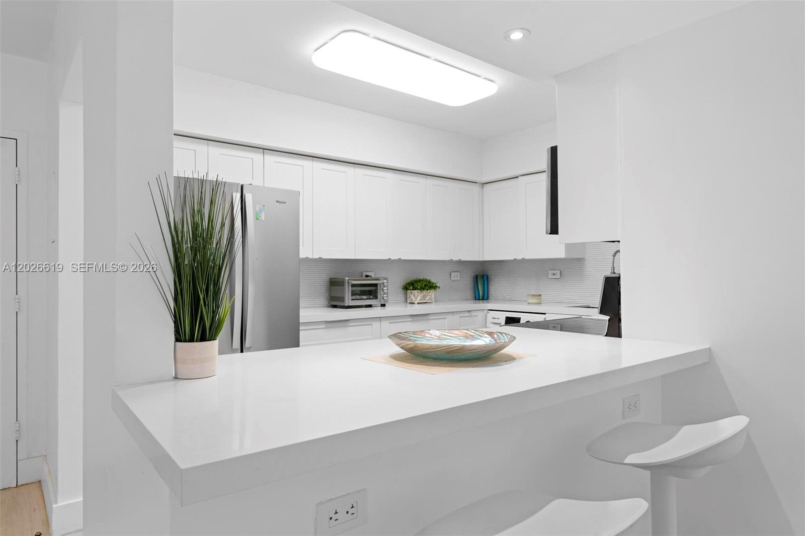 1500 Bay Road, Unit 1268S Miami Beach, FL 33139 - Photo 17 of 31 a kitchen with a sink a stove and white cabinets