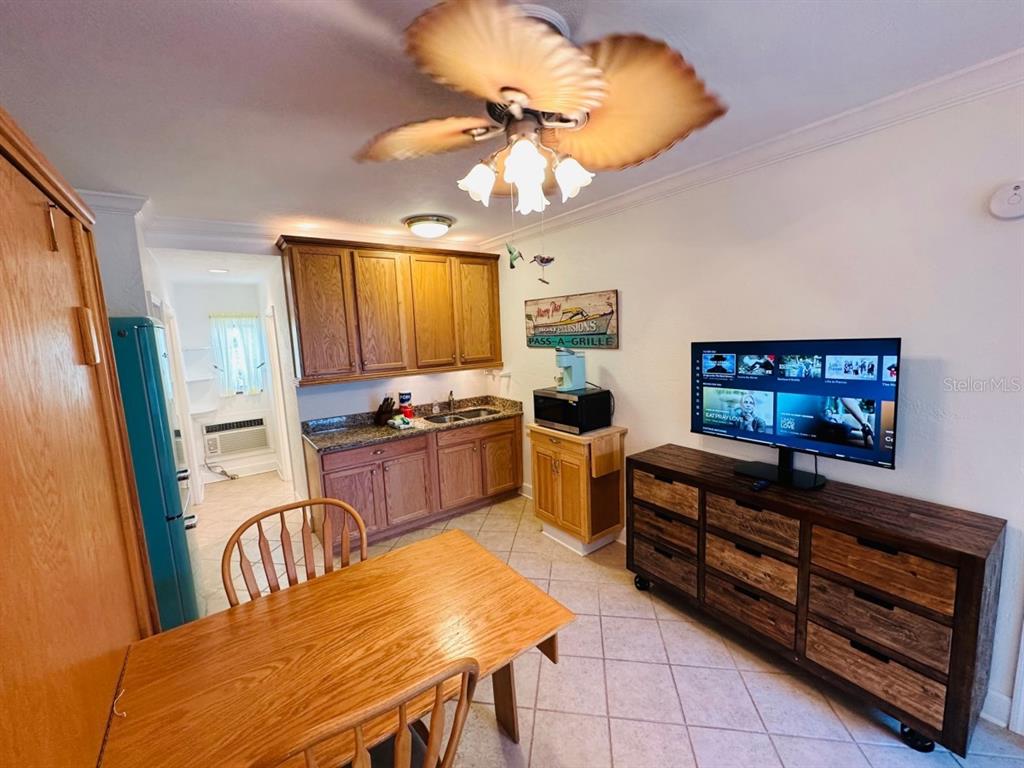 709 Gulf Way, Unit 19 St. Pete Beach, FL 33706 - Photo 13 of 39 a kitchen with stainless steel appliances granite countertop a stove top oven a sink a dining table and chairs with wooden floor