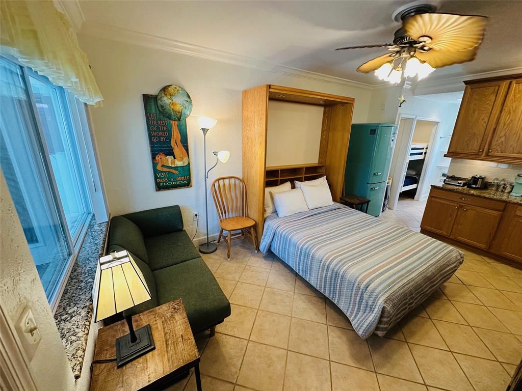 709 Gulf Way, Unit 19 St. Pete Beach, FL 33706 - Photo 16 of 39 a bedroom with a bed flat screen tv and dresser