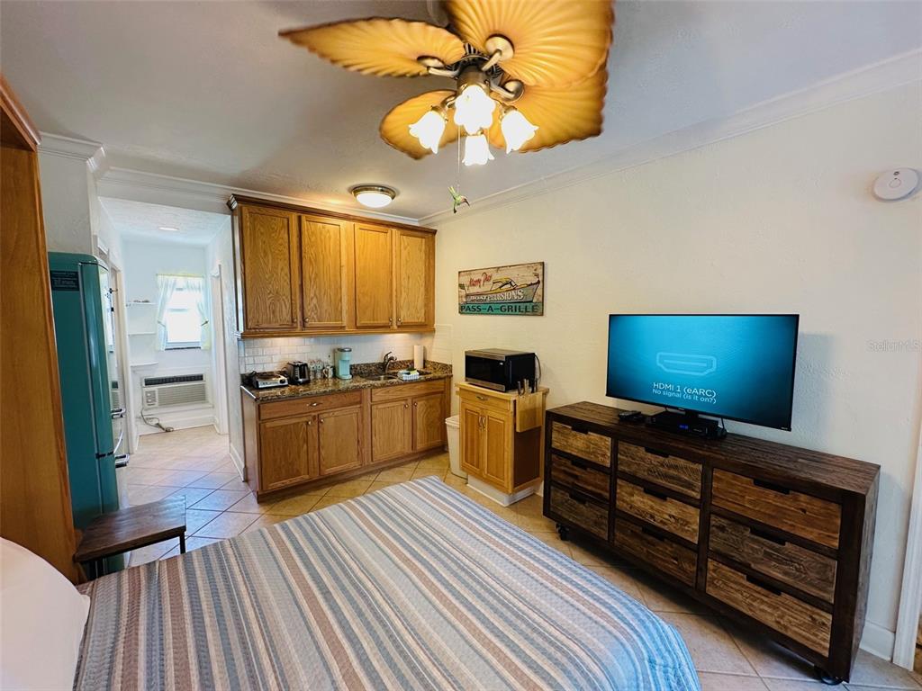 709 Gulf Way, Unit 19 St. Pete Beach, FL 33706 - Photo 19 of 39 a kitchen with stainless steel appliances kitchen island granite countertop a stove cabinets and wooden floor