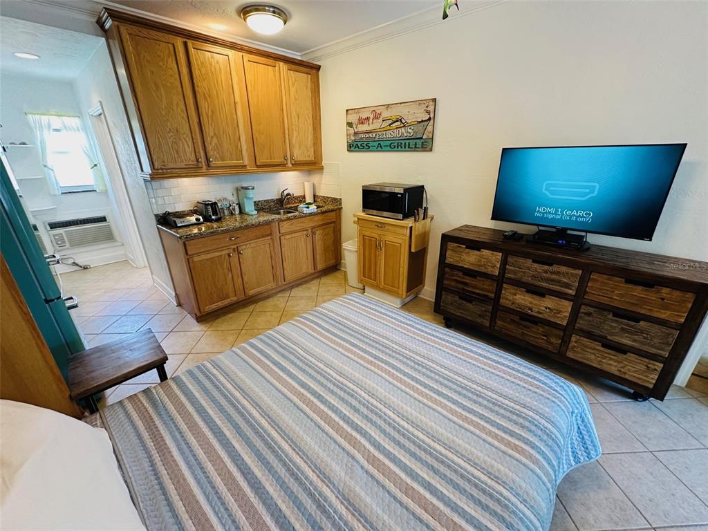 709 Gulf Way, Unit 19 St. Pete Beach, FL 33706 - Photo 20 of 39 a bedroom with furniture and a flat screen tv