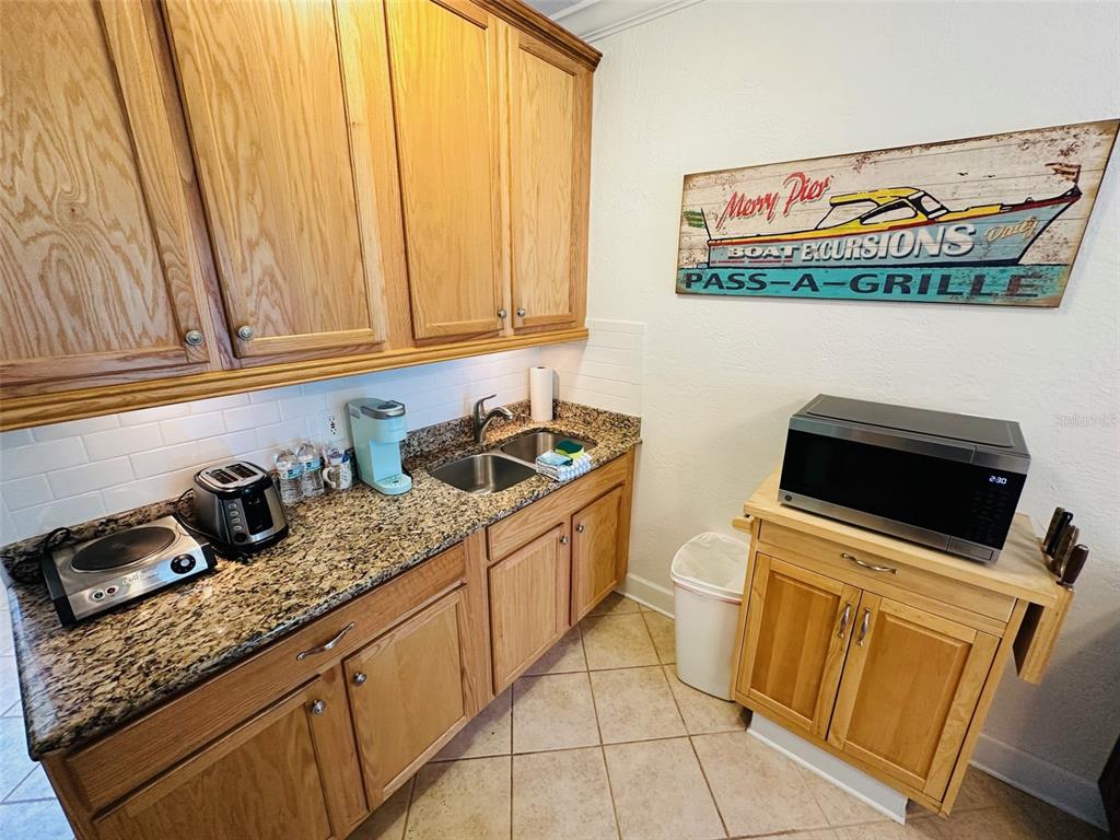 709 Gulf Way, Unit 19 St. Pete Beach, FL 33706 - Photo 22 of 39 a kitchen with stainless steel appliances a stove a sink and a microwave