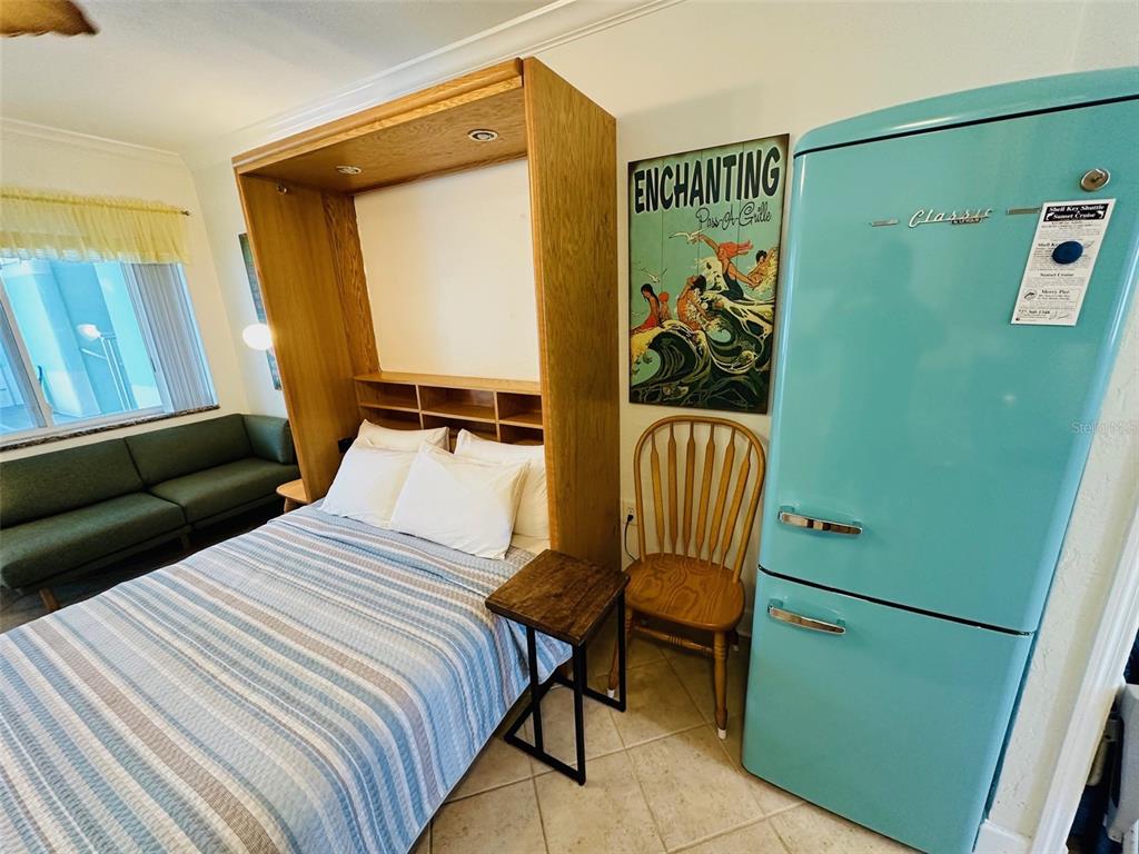 709 Gulf Way, Unit 19 St. Pete Beach, FL 33706 - Photo 24 of 39 a bedroom with a bed and a chair