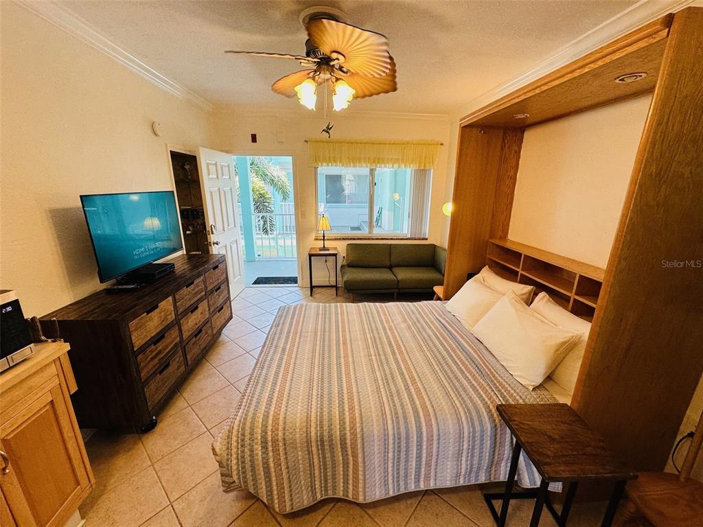 709 Gulf Way, Unit 19 St. Pete Beach, FL 33706 - Photo 25 of 39 a bedroom with a bed and a flat screen tv