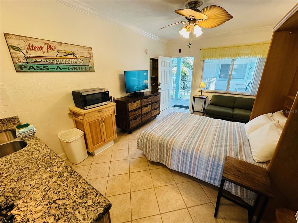 709 Gulf Way, Unit 19 St. Pete Beach, FL 33706 - Photo 26 of 39 a bedroom with furniture and a flat screen tv
