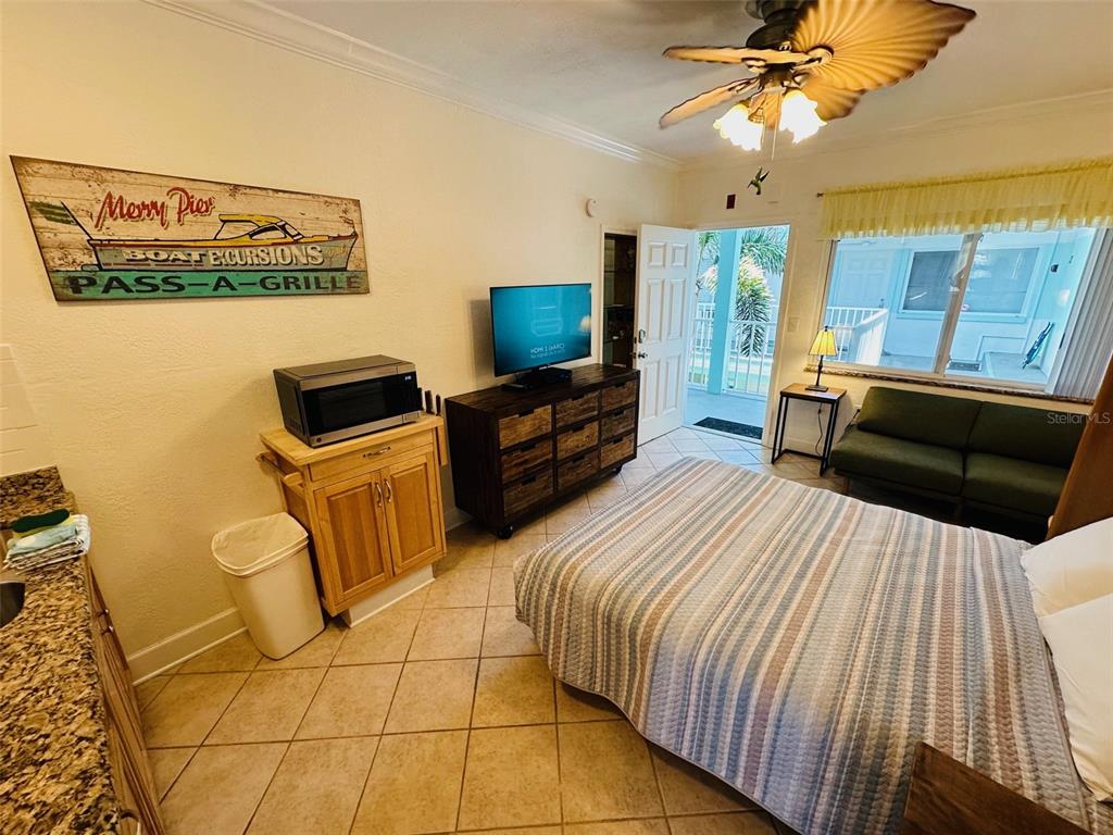 709 Gulf Way, Unit 19 St. Pete Beach, FL 33706 - Photo 27 of 39 a bedroom with a bed and a flat screen tv