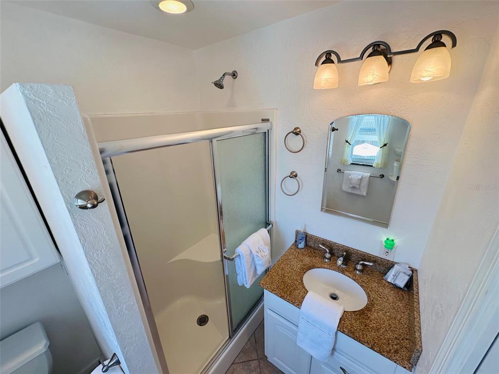 709 Gulf Way, Unit 19 St. Pete Beach, FL 33706 - Photo 33 of 39 a bathroom with a sink mirror vanity and toilet