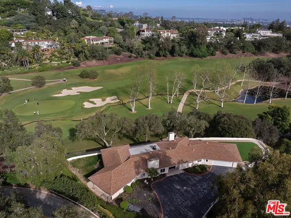 an aerial view of a house with a garden and lake view