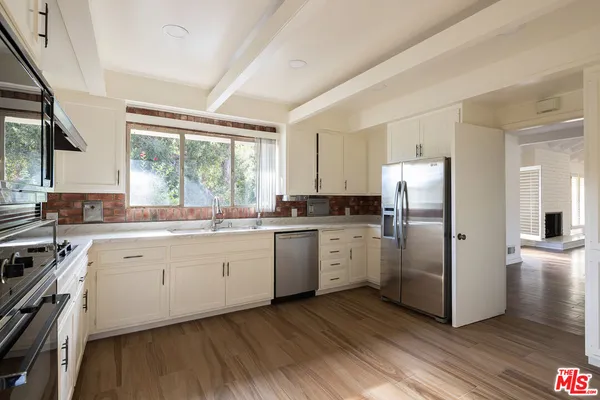 a view of empty room with wooden floor and fireplace