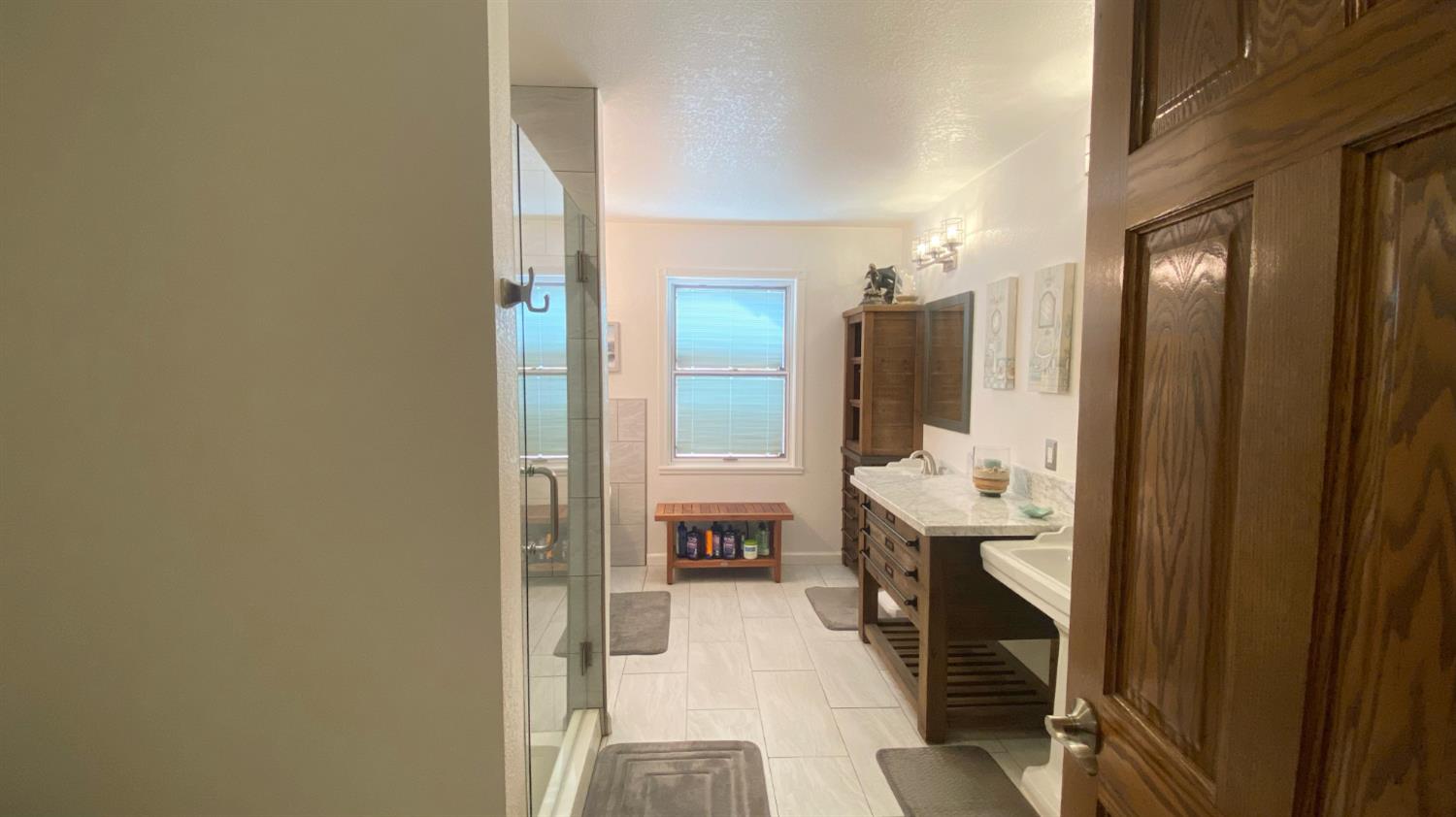 5012 Ustick Road Modesto, CA 95358 - Photo 22 of 26 a en suite bathroom with a sink and mirror with shower