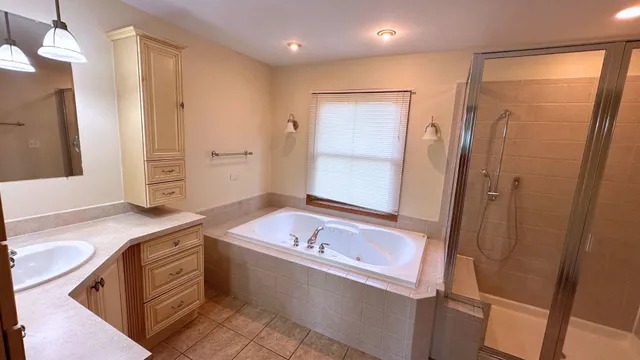 a bathroom with a tub sink and mirror
