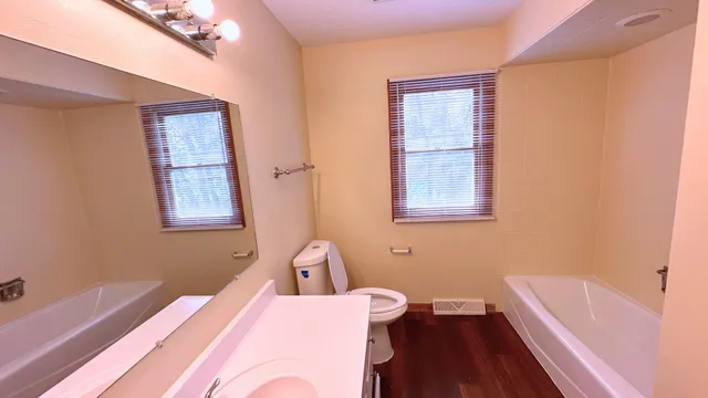 a bathroom with a sink a bathtub and a window