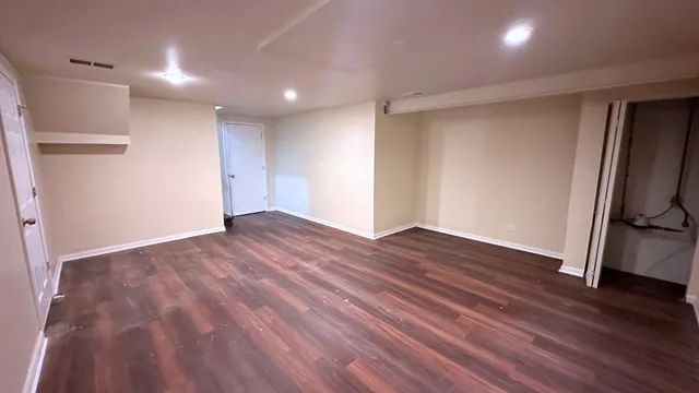 a view of empty room with wooden floor