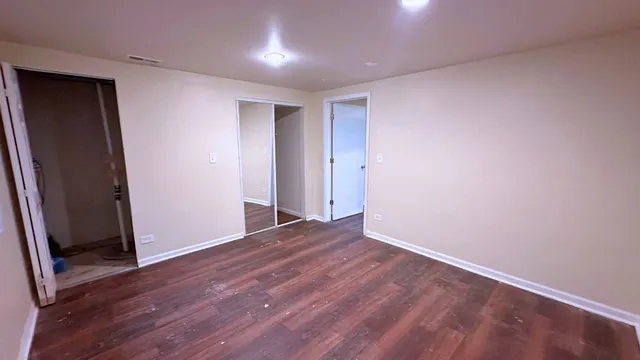 an empty room with wooden floor and closet
