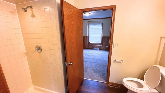 a bathroom with a toilet and a shower