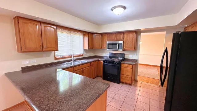 a kitchen with stainless steel appliances granite countertop a refrigerator a stove top oven a sink and dishwasher