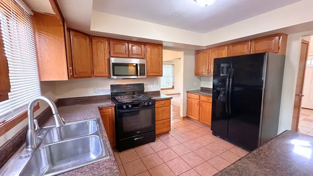 a kitchen with stainless steel appliances granite countertop a refrigerator stove and microwave