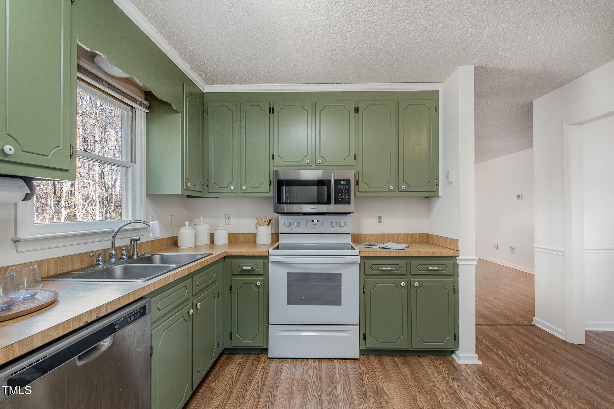 4213 Timberbrook Drive Raleigh, NC 27616 - Photo 9 of 37 a kitchen with a sink a microwave cabinets and wooden floor