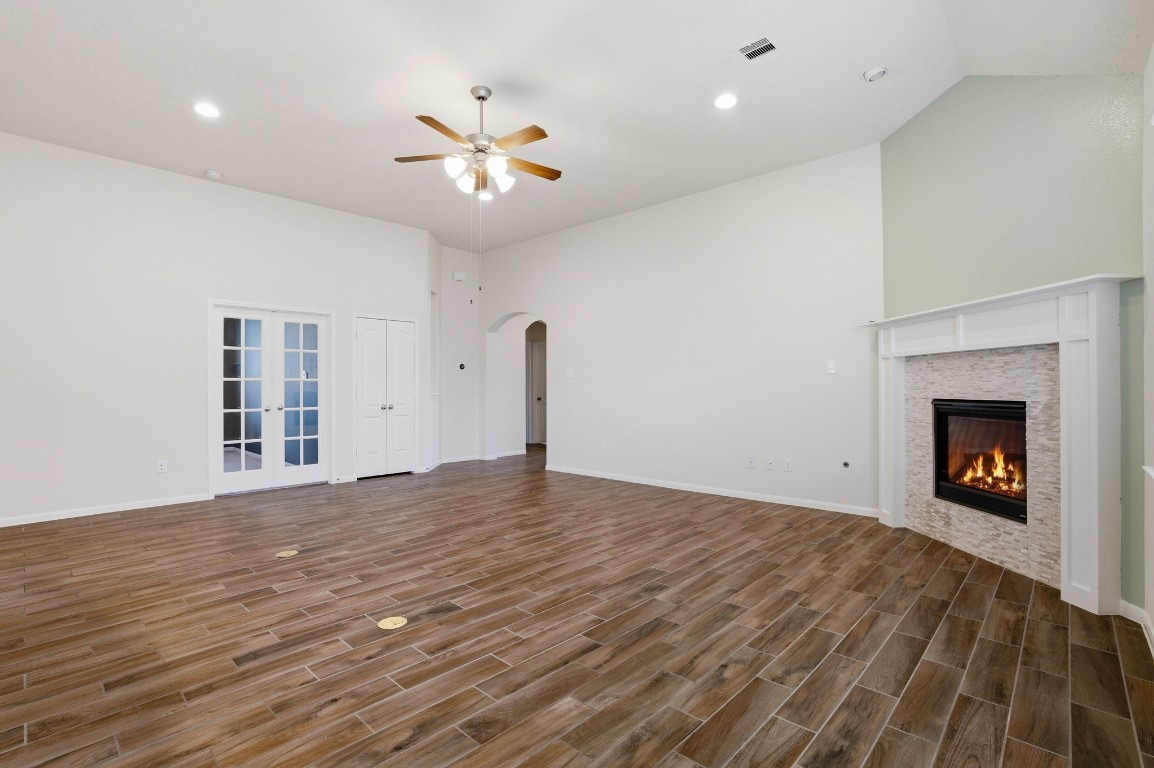 10007 Open Slope Court Humble, TX 77396 - Photo 11 of 39 a view of an empty room with a chandelier fan and a fireplace
