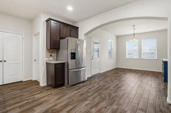 a kitchen with stainless steel appliances a refrigerator and wooden floor
