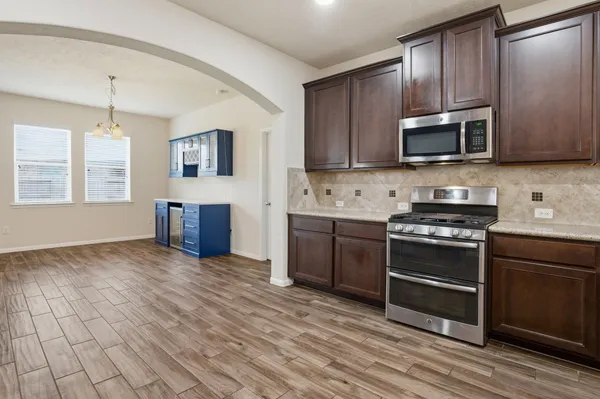 a kitchen with stainless steel appliances granite countertop a stove a sink and a microwave