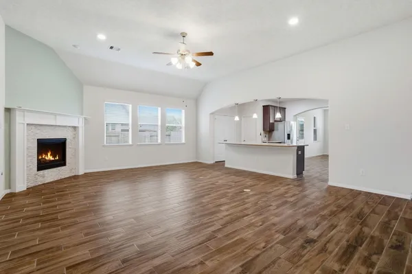 a view of an empty room with a window and wooden floor