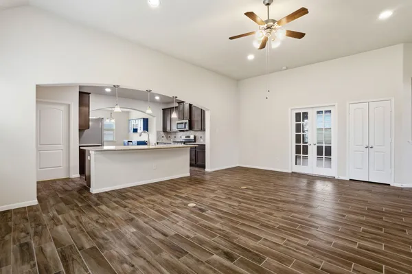 a view of a kitchen with kitchen island a sink wooden floor and a refrigerator