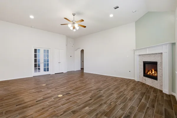 a view of an empty room with window and wooden floor