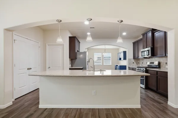 a large kitchen with kitchen island a sink stainless steel appliances and cabinets